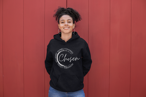 Model is wearing a Black hoodie with a graphic design that says Chosen in script font and the words redeemed, loved, set apart and divinely favored around it